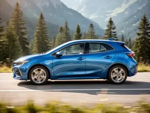 Srebrny Opel Tigra zaparkowany na malowniczej nadmorskiej drodze podczas zachodu słońca.