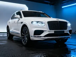 Cupra Leon Sportstourer zaparkowana na malowniczej nadmorskiej drodze podczas zachodu słońca.